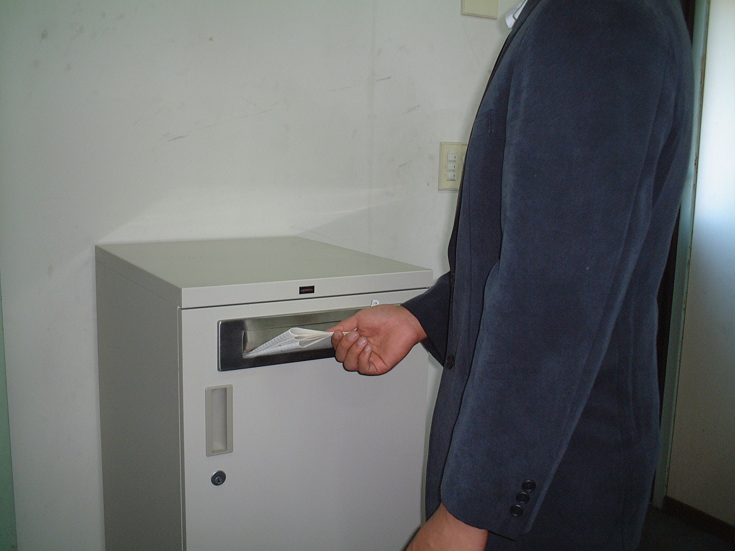 機密書類回収ボックスに書類を投入する様子